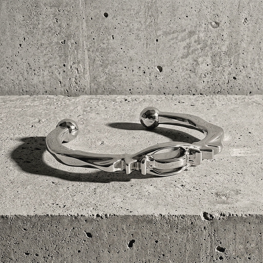 Polished sterling silver bracelet revealing the flow of the band and the faceted sphere terminals