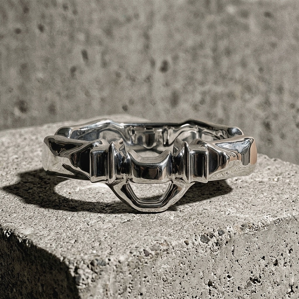 Sculptural ring with undulating band and architectural crown composition on concrete, A Gross Domestic Product