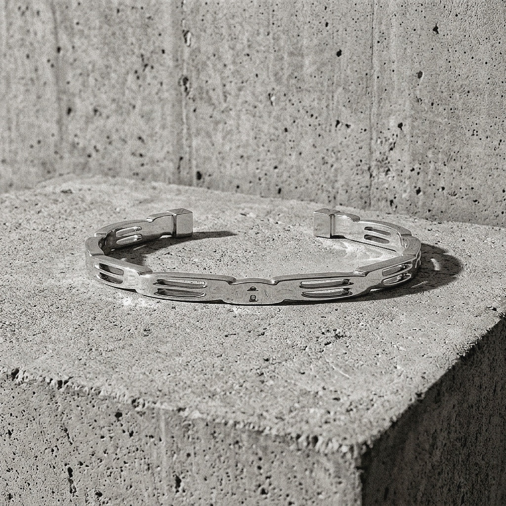 Sterling silver cuff showing the rhythm of carved oval reliefs along the band on concrete surface, 925 silve