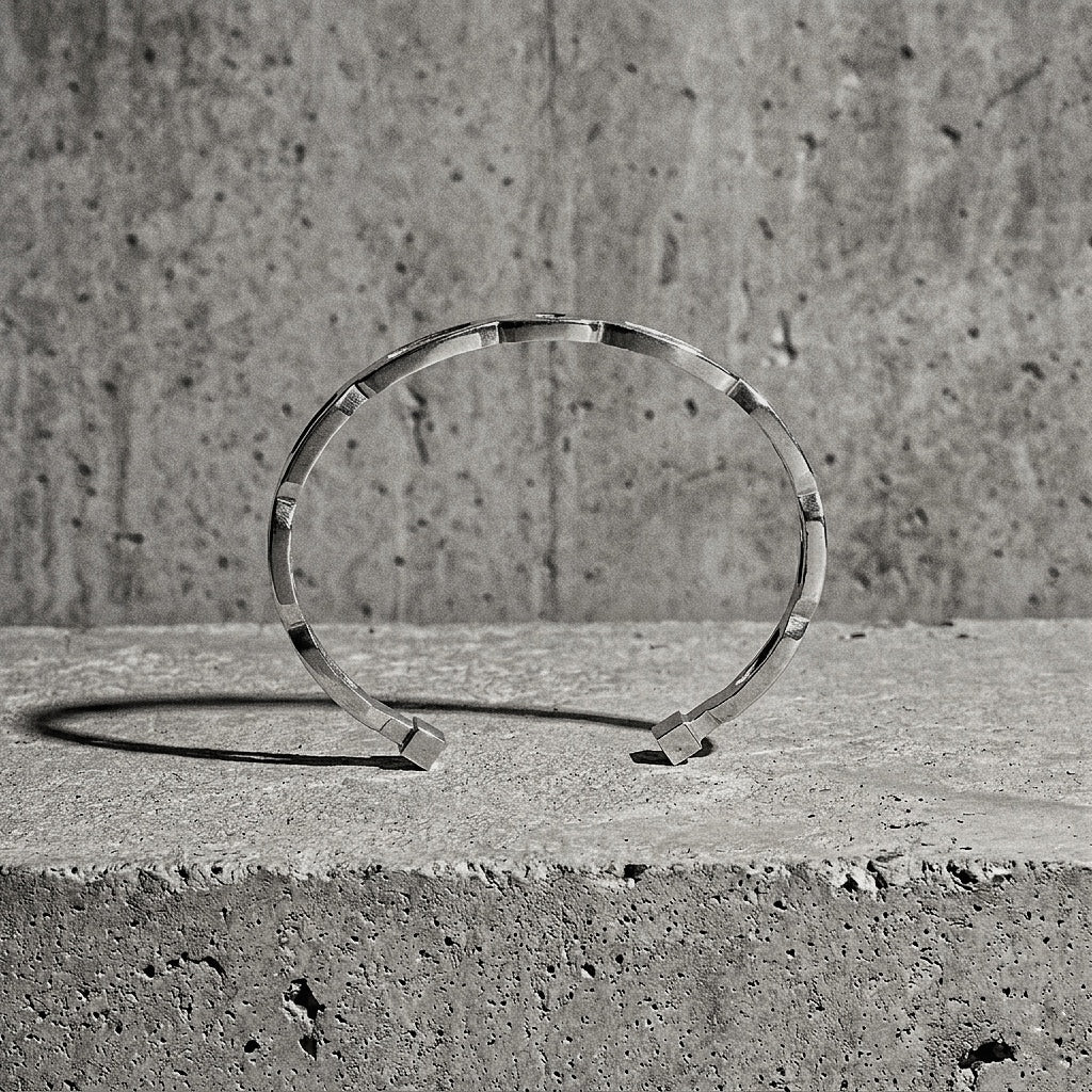 5 mm thick sterling silver cuff revealing the stepped upper edge and squared terminals against concrete wall