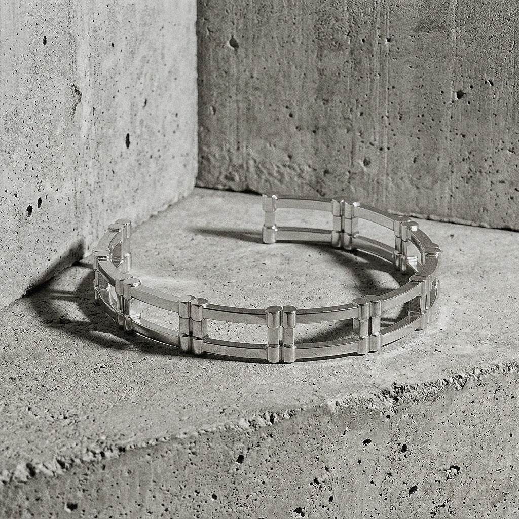 Solid sterling silver cuff revealing the ladder construction and squared terminals against concrete wall