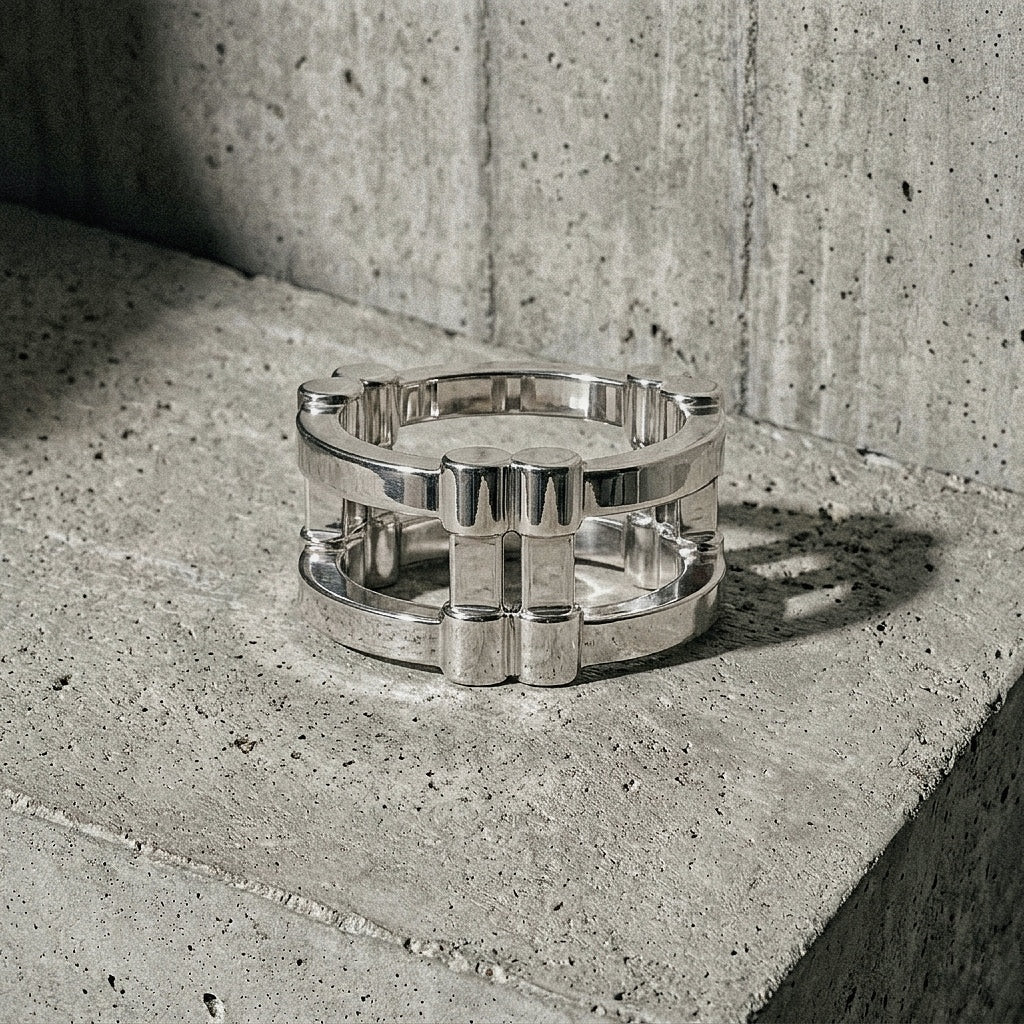 Wide band architectural silver ring on concrete surface, top view
