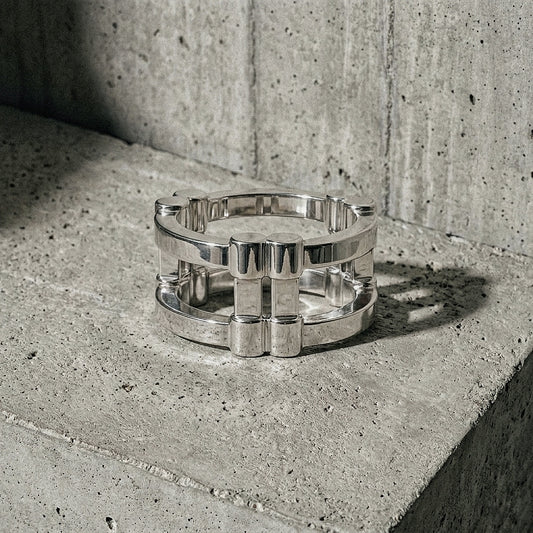 Wide band architectural silver ring on concrete surface, top view