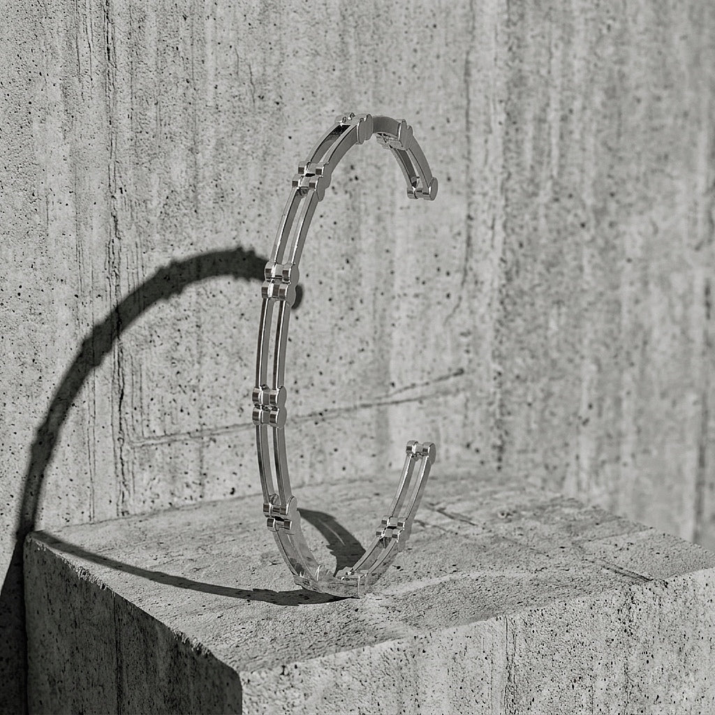 Ten Cuff Bracelet in sterling silver — open cuff standing on concrete, A Gross Domestic Product