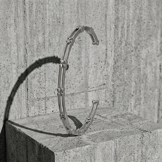 Ten Cuff Bracelet in sterling silver — open cuff standing on concrete, A Gross Domestic Product